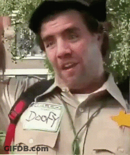 A Man Wearing A Name Tag That Says Doofy On It GIF