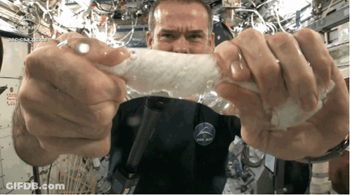 A Man Wearing A Nasa Shirt Is Holding A Piece Of Plastic GIF