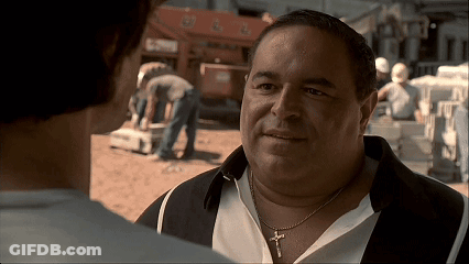 A Man Wearing A Necklace With A Cross On It GIF