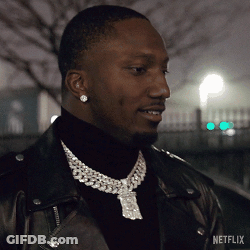 A Man Wearing A Necklace With A Netflix Logo On It GIF