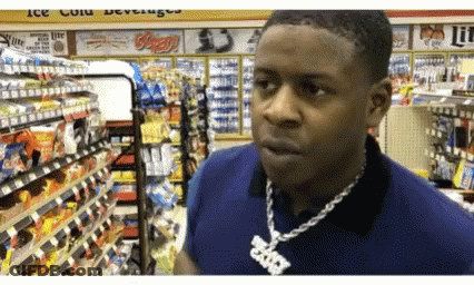 A Man Wearing A Necklace With A Pendant That Says ' Brooklyn ' On It Is In A Store GIF