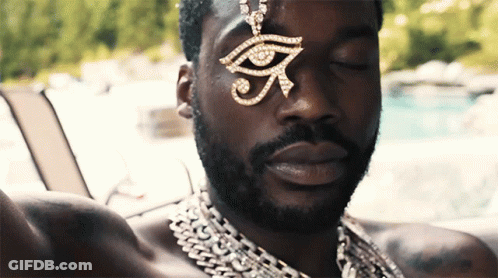 A Man Wearing A Necklace With An Eye Pendant GIF