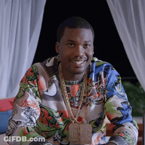 A Man Wearing A Necklace With The Letter D On It Smiles GIF