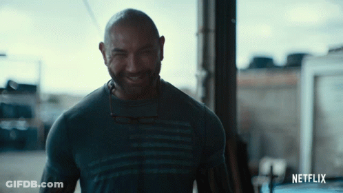 A Man Wearing A Netflix Shirt Is Smiling GIF