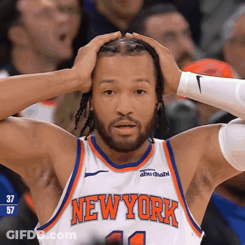 A Man Wearing A New York Jersey Holds His Head In His Hands GIF