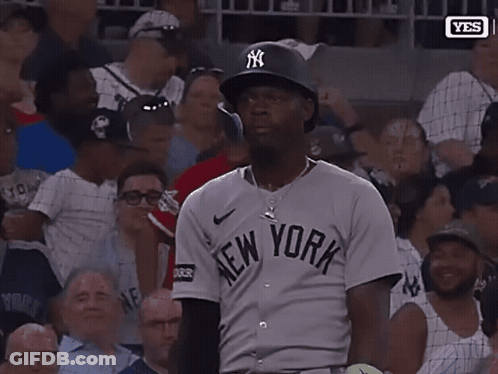 A Man Wearing A New York Jersey Holds Up His Hand GIF