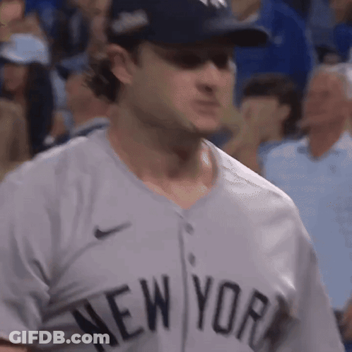 A Man Wearing A New York Jersey Is Standing In The Crowd GIF