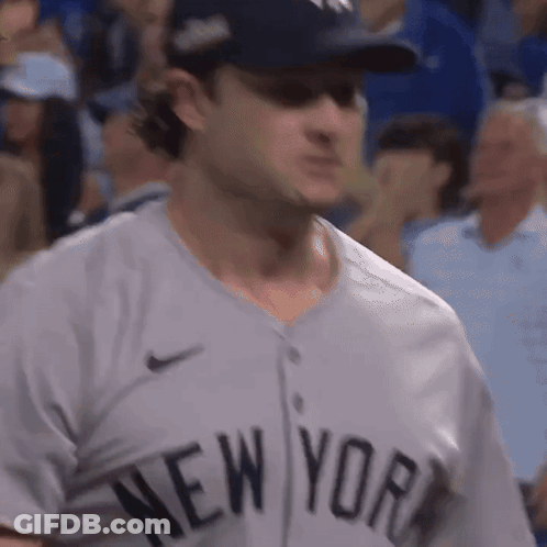 A Man Wearing A New York Jersey Is Standing In The Crowd GIF