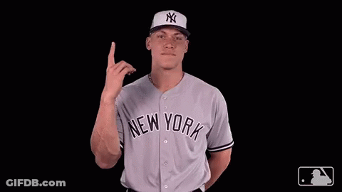 A Man Wearing A New York Jersey Points Upwards GIF