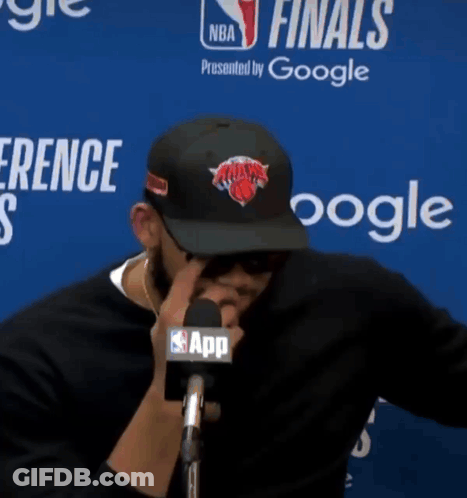 A Man Wearing A New York Knicks Hat Talks Into A Microphone At A Nba Finals Press Conference GIF