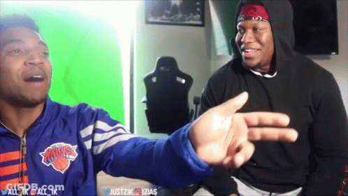 A Man Wearing A New York Knicks Jacket Is Pointing At Another Man GIF
