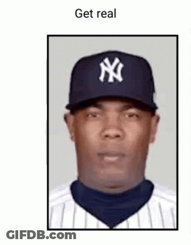 A Man Wearing A New York Yankees Hat And Striped Shirt Is Looking At The Camera . GIF