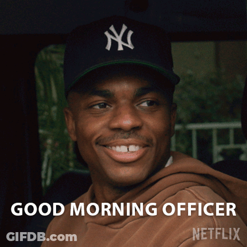 A Man Wearing A New York Yankees Hat Is Smiling And Says Good Morning Officer Netflix GIF