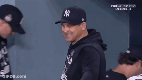 A Man Wearing A New York Yankees Hat Is Smiling During A Fox World Series Game GIF