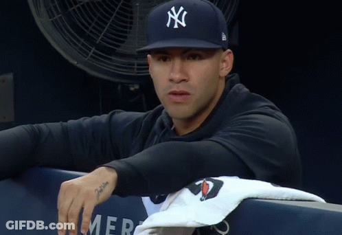 A Man Wearing A New York Yankees Hat Sits In A Dugout GIF