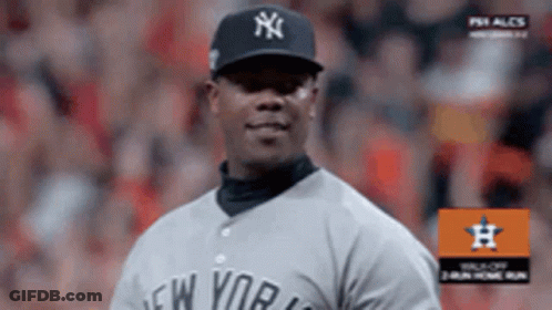 A Man Wearing A New York Yankees Jersey Stands On A Baseball Field GIF