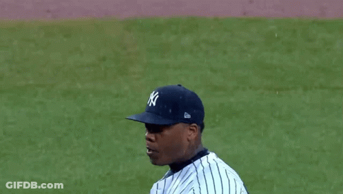 A Man Wearing A New York Yankees Jersey With His Mouth Wide Open GIF