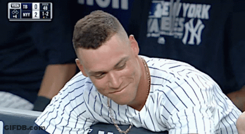 A Man Wearing A New York Yankees Shirt Looks Down GIF