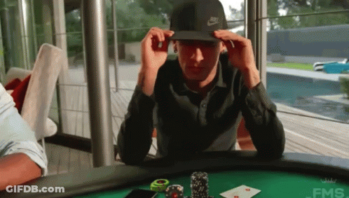 A Man Wearing A Nike Hat Is Sitting At A Poker Table GIF