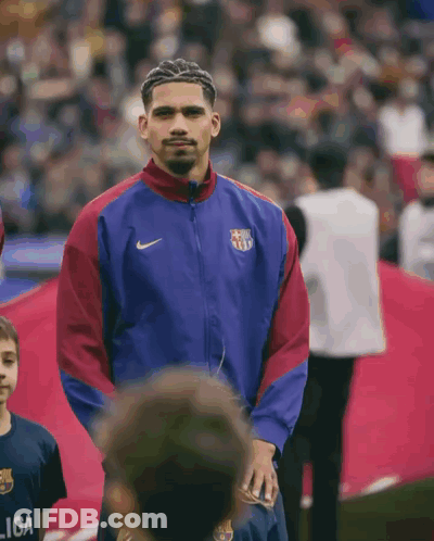 A Man Wearing A Nike Jacket Stands In Front Of A Crowd GIF
