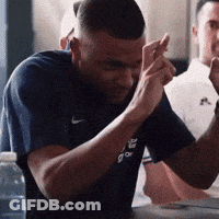 A Man Wearing A Nike Shirt Is Holding His Hands Together GIF