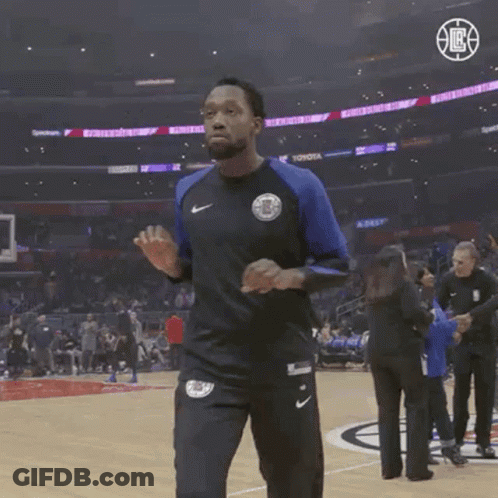 A Man Wearing A Nike Shirt Is Walking On A Basketball Court .. GIF