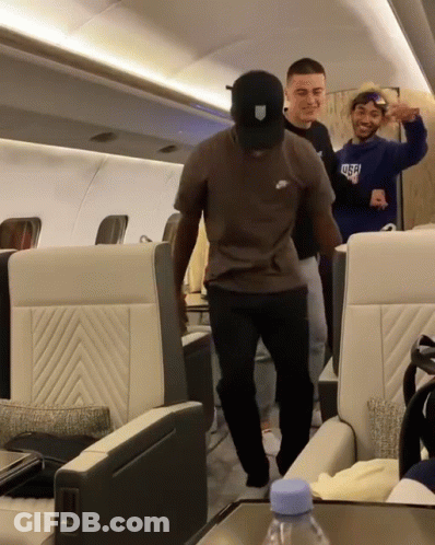 A Man Wearing A Nike T-Shirt Is Dancing On A Plane GIF