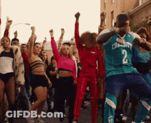 A Man Wearing A Number 2 Jersey Is Dancing With A Group Of People GIF