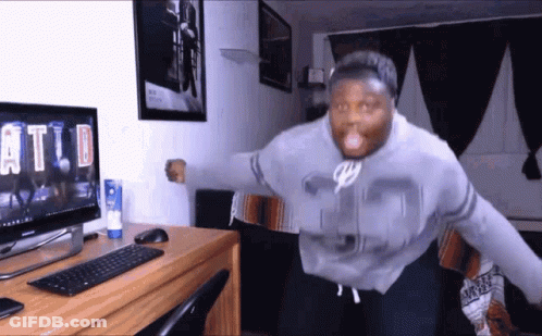 A Man Wearing A Number 35 Sweatshirt Is Standing In Front Of A Computer Monitor GIF