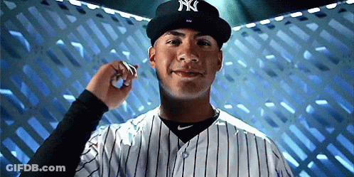 A Man Wearing A Ny Hat And Striped Shirt GIF