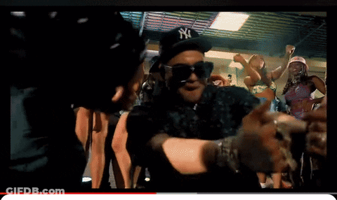 A Man Wearing A Ny Hat And Sunglasses Is Dancing In A Crowd GIF