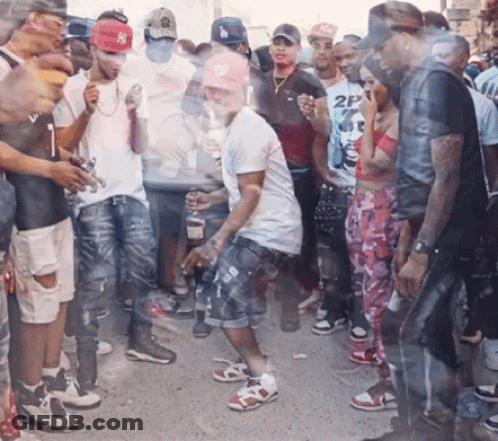 A Man Wearing A Ny Hat Is Dancing In A Crowd GIF