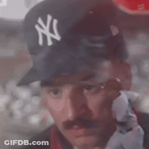 A Man Wearing A Ny Yankees Hat Looks Out A Window GIF