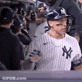 A Man Wearing A Ny Yankees Jersey Stands In A Crowd GIF