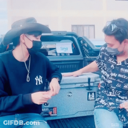 A Man Wearing A Ny Yankees Sweatshirt Sits Next To Another Man GIF