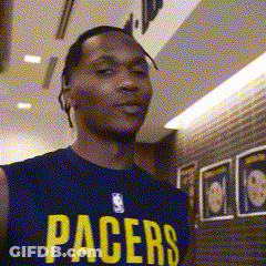 A Man Wearing A Pacers Jersey Stands In Front Of A Brick Wall GIF