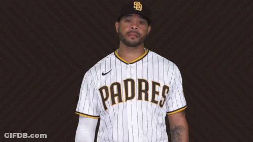 A Man Wearing A Padres Jersey Is Standing In Front Of A Brown Background GIF