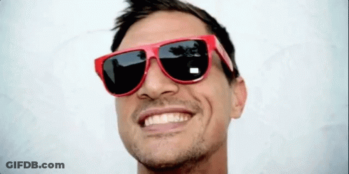 A Man Wearing A Pair Of Red Sunglasses Smiles For The Camera GIF