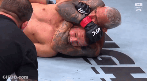 A Man Wearing A Pair Of UFC Boxing Gloves Holds Another Man 'S Head GIF