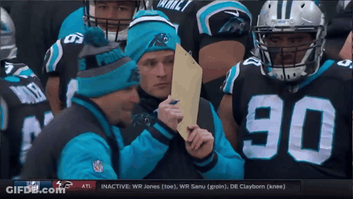 A Man Wearing A Panthers Hat Holds A Piece Of Paper GIF