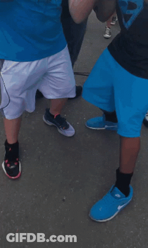 A Man Wearing A Panthers Shirt Stands Next To Another Man Wearing A Mask GIF
