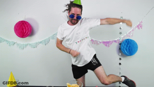A Man Wearing A Party Hat And Sunglasses Holds A Star In His Hands GIF