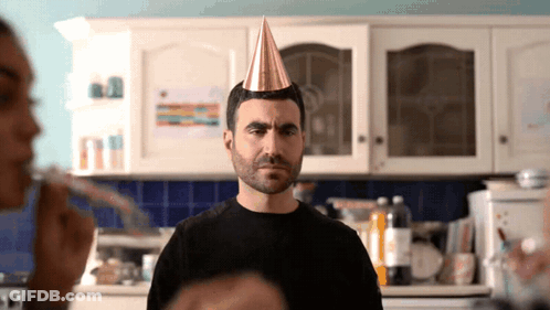 A Man Wearing A Party Hat Is Looking At The Camera GIF