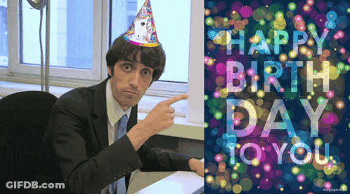 Man In Party Hat Pointing At Happy Birthday Card GIF
