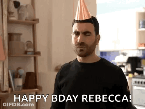 A Man Wearing A Party Hat Is Standing In A Kitchen And Saying Happy Bday Rebecca . GIF