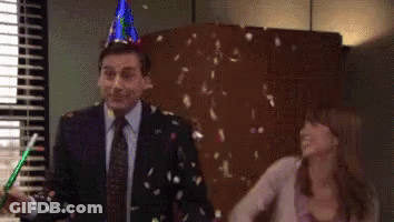 A Man Wearing A Party Hat Is Standing Next To A Woman Who Is Throwing Confetti At Him . GIF