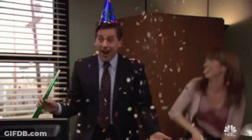 A Man Wearing A Party Hat Is Throwing Confetti In The Air GIF