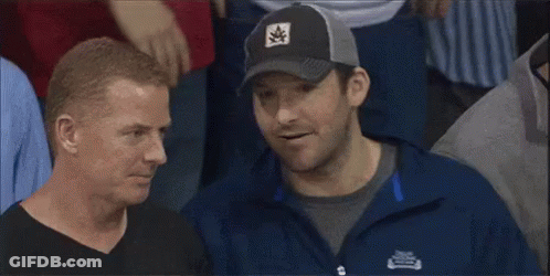 A Man Wearing A Patagonia Jacket Is Talking To Another Man In A Crowd GIF