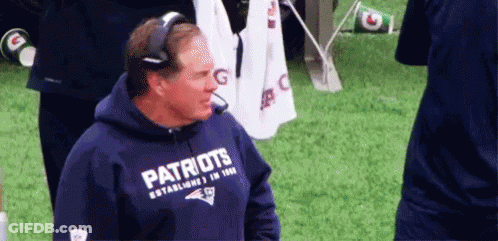 A Man Wearing A Patriots Hoodie Is Standing On A Field . GIF