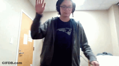 A Man Wearing A Patriots Shirt Is Waving At The Camera GIF